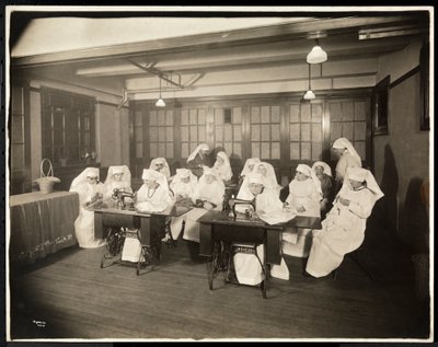 Femmes portant des blouses blanches, dans un cours de couture, probablement pendant ou en lien avec la Première Guerre mondiale, New York, c.1920 - Byron Company